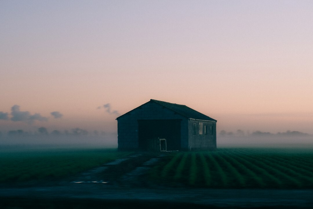 Rustic modern country house with open fields at sunset